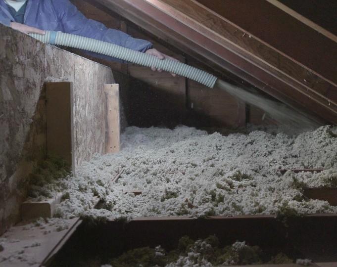 Mineral wool fiber insulation is blown into an attic